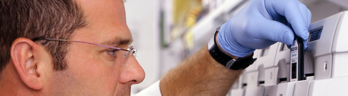 Doctor inserts gene chip into a machine.