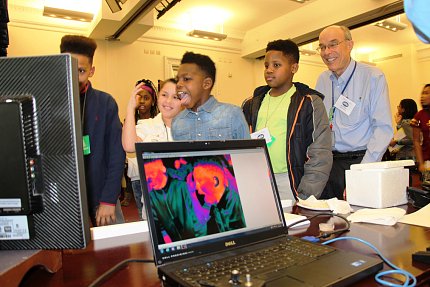 Students react as an infrared camera reveals heat radiating from their skin, also shown on the laptop monitor