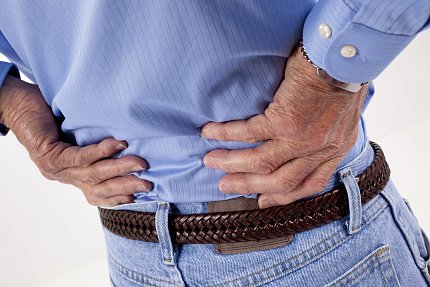 A man holds his lower back