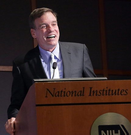 Sen. Warner smiles at podium.