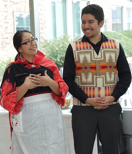 Capitan, Calac in traditional Native American clothing, smile while chatting.