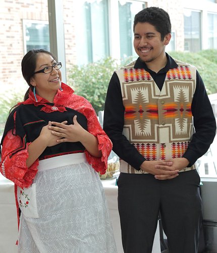 Capitan, Calac in traditional Native American clothing, smile while chatting.