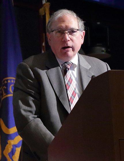 Tabak speaks at podium