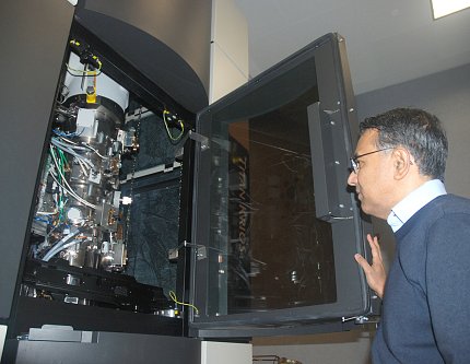 Dr. Subramaniam looks inside his EM machine.