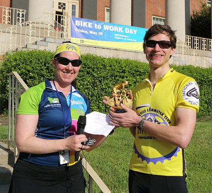 Man accepting trophy from woman