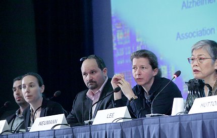 Five people seated behind microphones at panel table