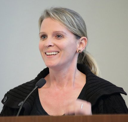 Lora Kutkat speaks at podium