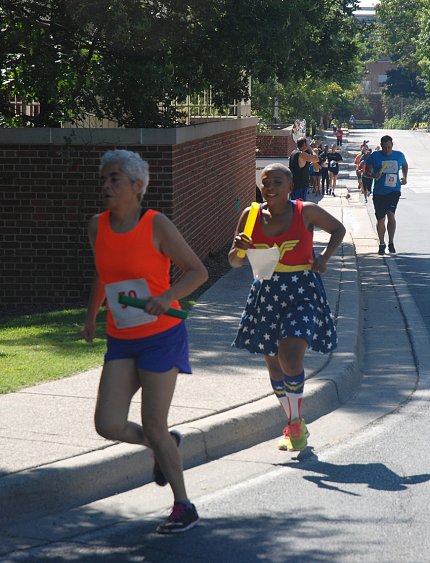 Woman dressed as Wonder Woman, in red, white &amp; blue, running