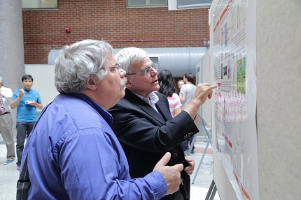 Dr. Gottesman points at poster.