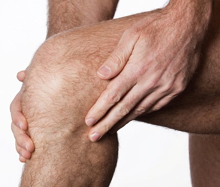 A man rubs his aching knee