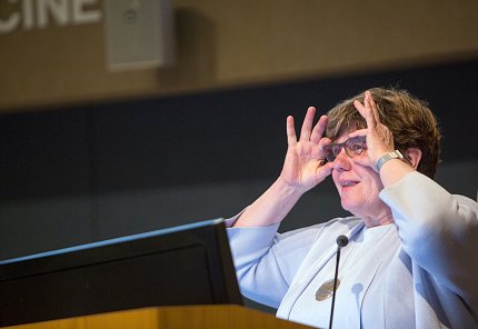 Brennan gestures with both hands at her face.