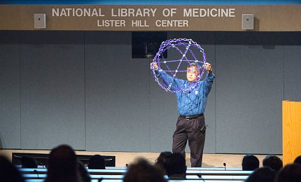 Loo holds up a ball constructed of strings of light.