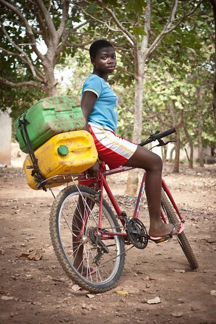 Woman uses bike to haul water.