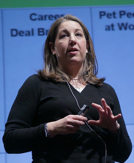 Harley stands speaking on stage