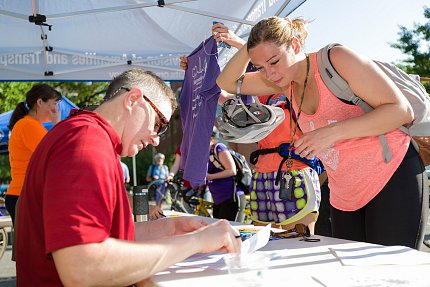 Sakalian and Virta work behind a table to register cyclists.