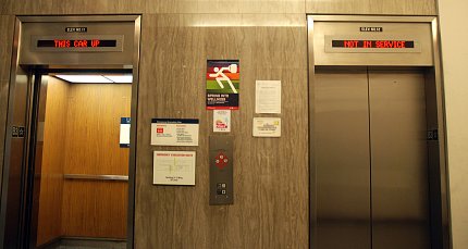 A pair of elevators in Building 31, one of which displays sign above, "Not in service."