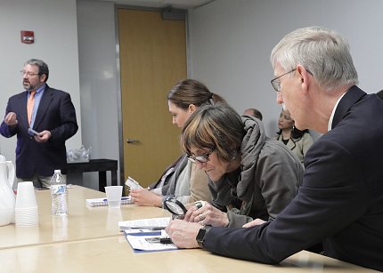 Rep. DeLauro and Dr. Collins look through magnifying glass.