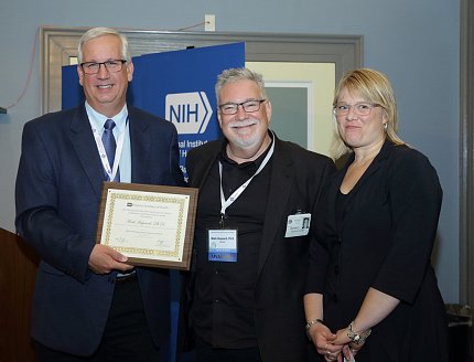 Hayward receives an award from Riley and Spotts