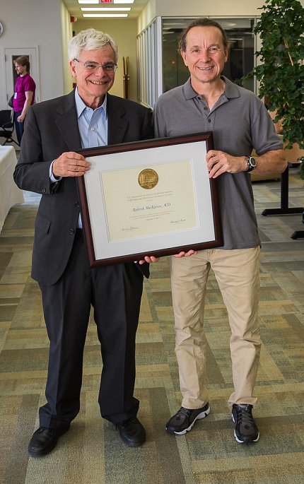 MacKinnon and Gottesman hold up a plaque