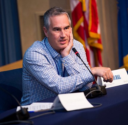 Hall speaks into a microphone