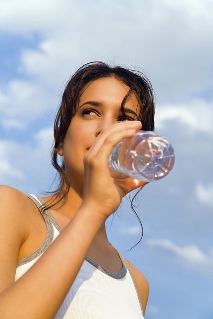 Young woman sipping from bottled water