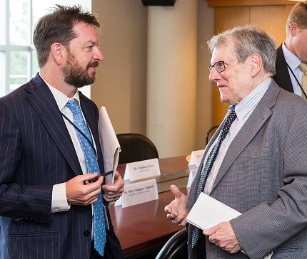 Katz with OMB's Grogan stand, talking in a conference room.