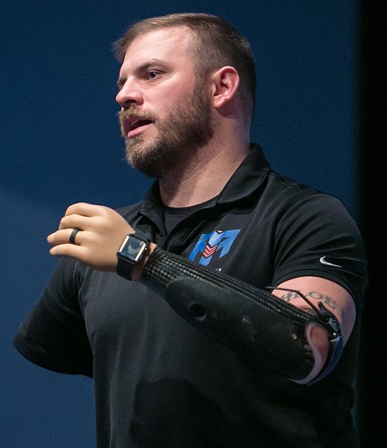 Mills raises his prosthetic arm