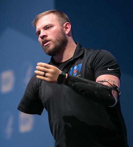 Mills raises his prosthetic arm