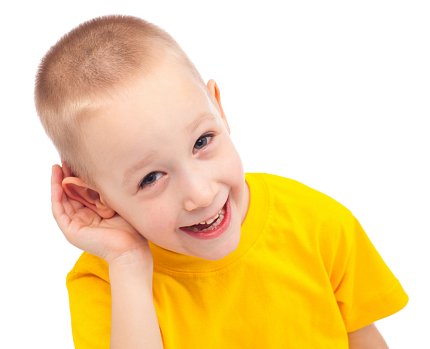 Smiling boy listening with his hand to his ear.