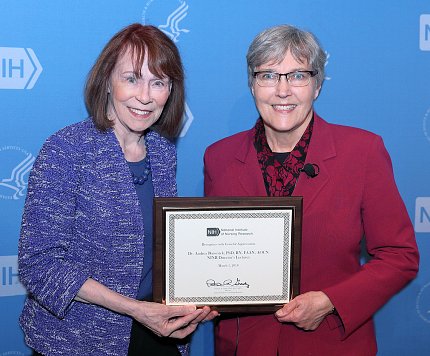NINR director Dr. Patricia Grady presents plaque to Barsevick.