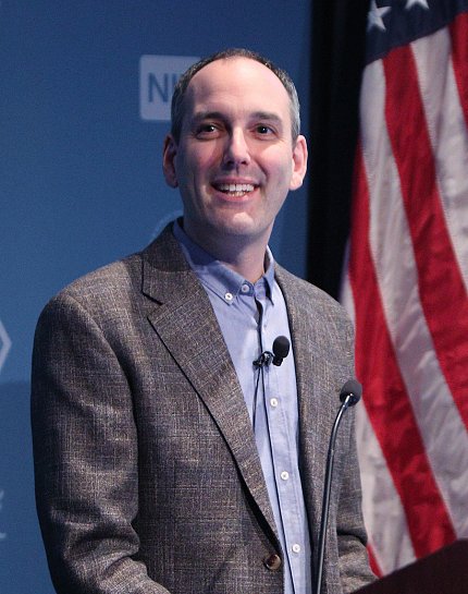 Chesler speaking at the podium.