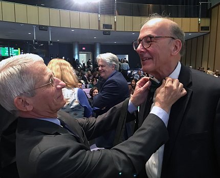 Dr. Anthony Fauci assists Glass with his emerald green bow tie.