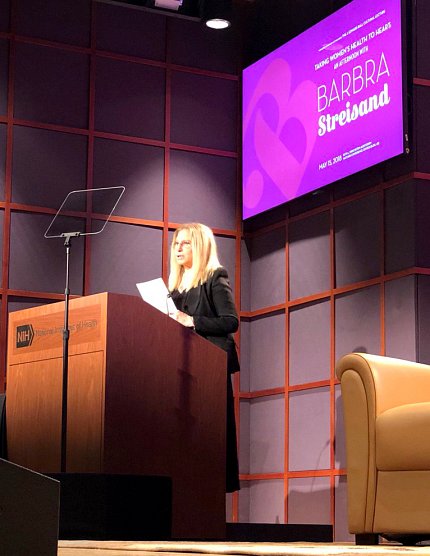 Streisand speaking at the podium.