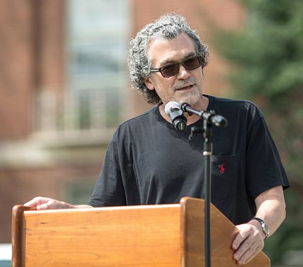 Pérez-Stable speaking at a podium outside.