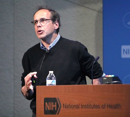 Stainier speaking from behind the podium.