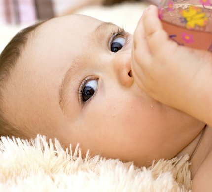 A baby drinks from his bottle
