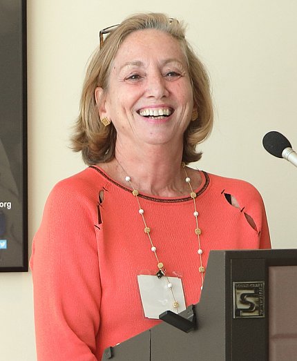 Alexander smiling as she speaks at the podium