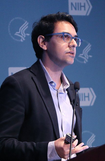 Dr. Neville Sanjana speaking at the podium.