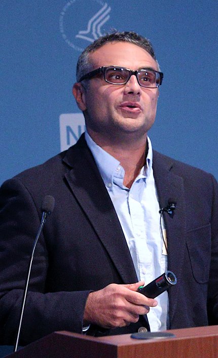 Dr. Omer Yilmaz speaking at the podium.