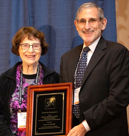 Dr. Geller receives a plaque from Dr. Grafstein