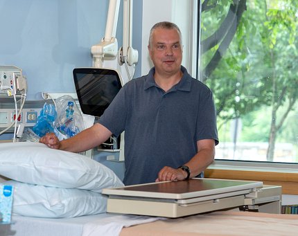 Kaminski stands behind a hospital bed