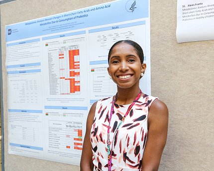 Franks stands in front of her poster