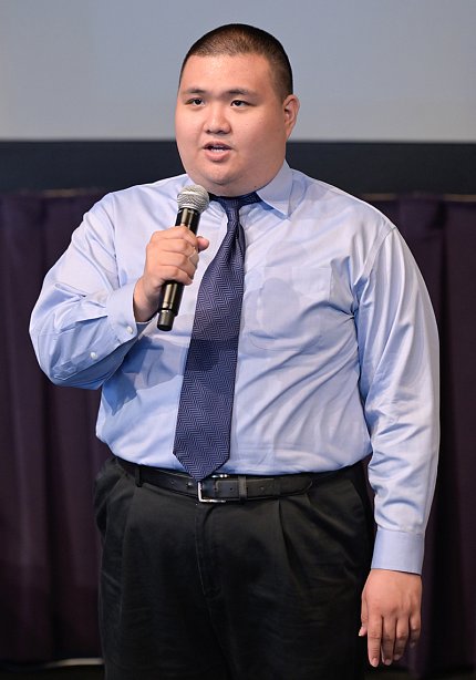 James Garcia stands on stage, singing into the microphone.