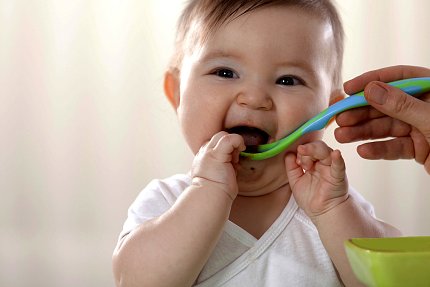 A baby eats a spoonful of food