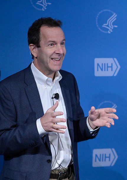 Salzberg stands at podium, smiling as he describes his research.