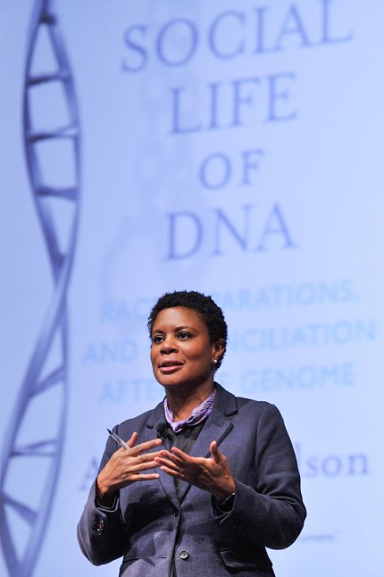 Dr. Alondra Nelson speaks in front of slide showing double helix that reads the social life of DNA