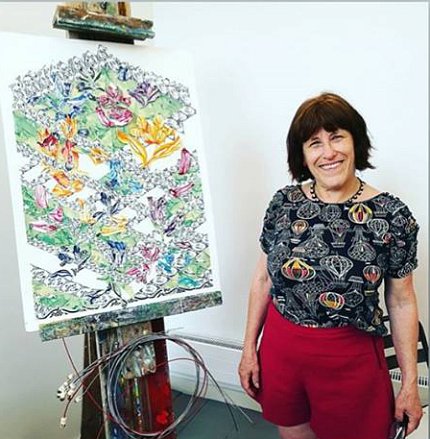 Foer stands next to an easel that displays her artwork