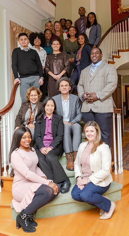 Group of iCURE scholars and staff pose with NCI leadership on a winding staircase.