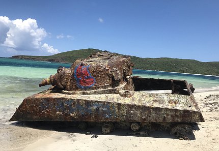 A rusty military tank sits on a beach in Puerto Rico