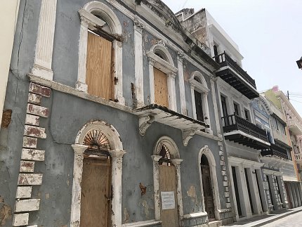 A damaged, boarded-up apartment building